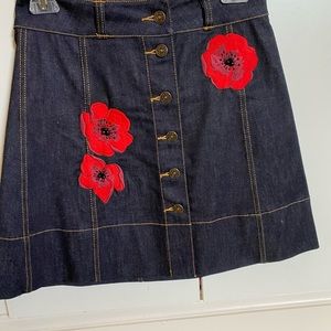 Kate Spade Broome Street jean skirt with red flower embellishment.